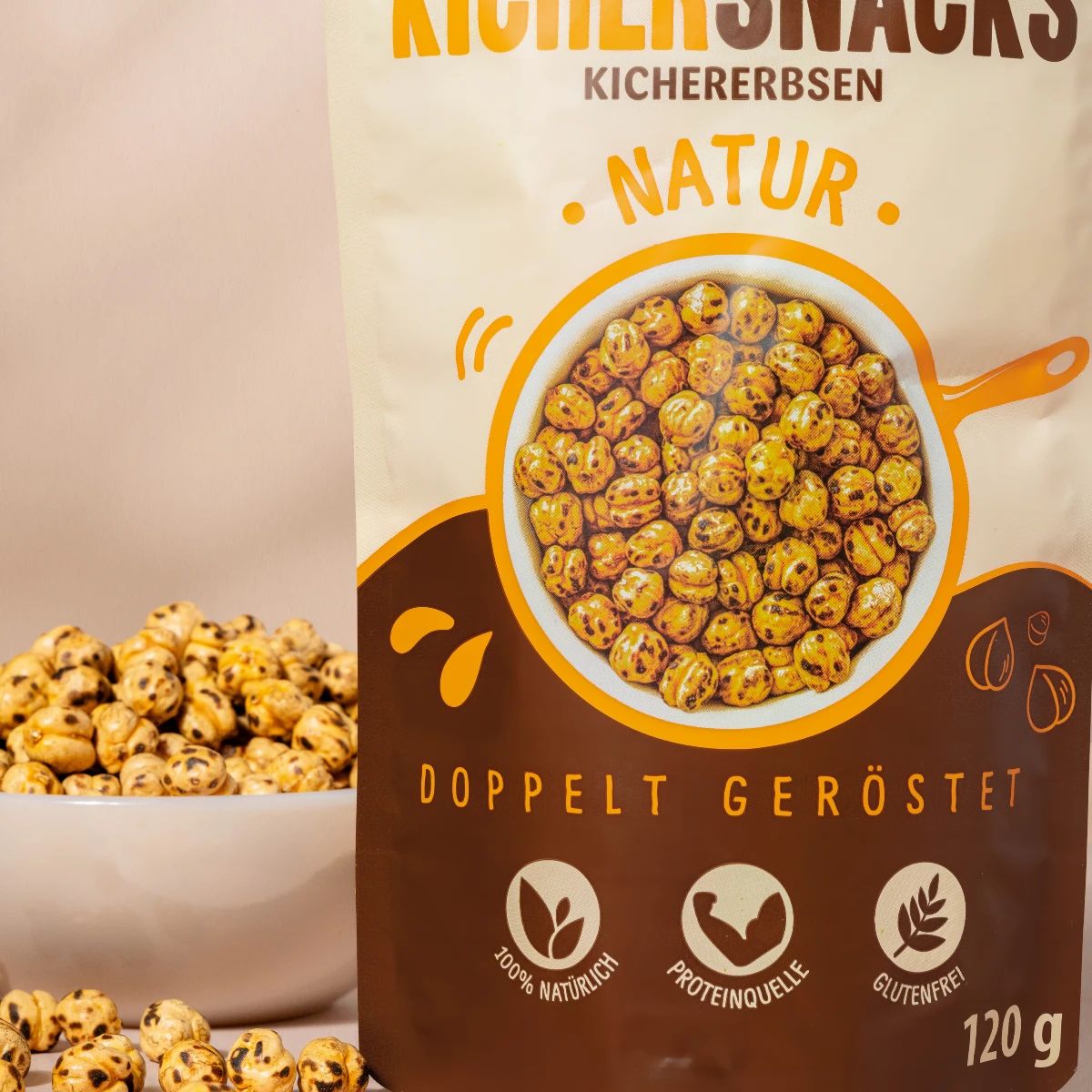 Nahaufnahme eines Beutels mit Kichererbsen-Snacks. Aufschrift: NutriPur, Kichererbsen Snacks, Natur, doppelt geröstet. Eine Schüssel mit Kichererbsen daneben.