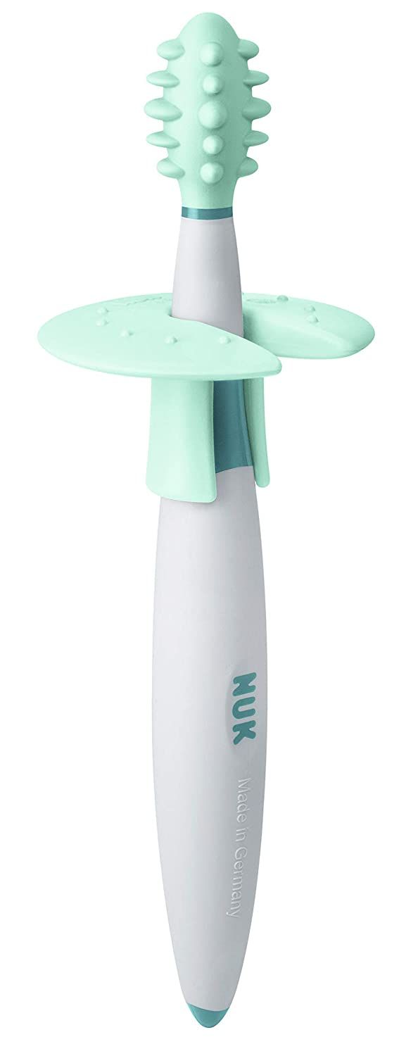 Zahnputztrainer mit grünem Borstenkopf, weißem Griff, blauem Mittelteil und Schutzring. NUK-Logo und Made in Germany.