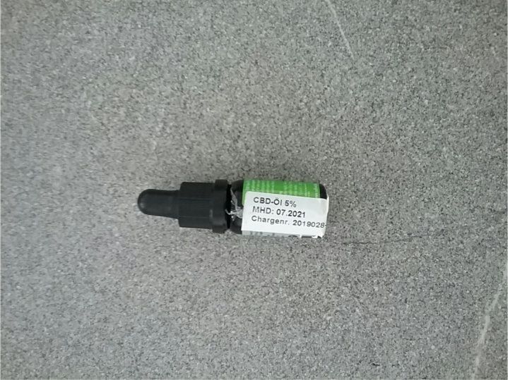 CBD-Öl 5% in einer kleinen Glasflasche mit Tropfer. Aufkleber mit Produktinformationen.