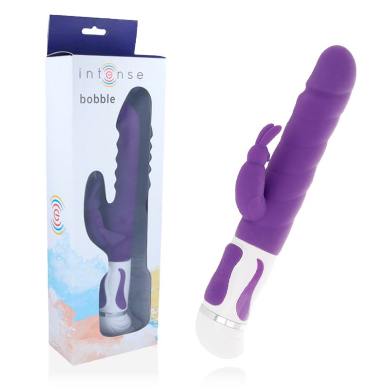 Verpackung und Vibrator. Aufschrift 'intense bobble'. Lila Vibrator mit Hasenohren-Aufsatz. Weißer Sockel.