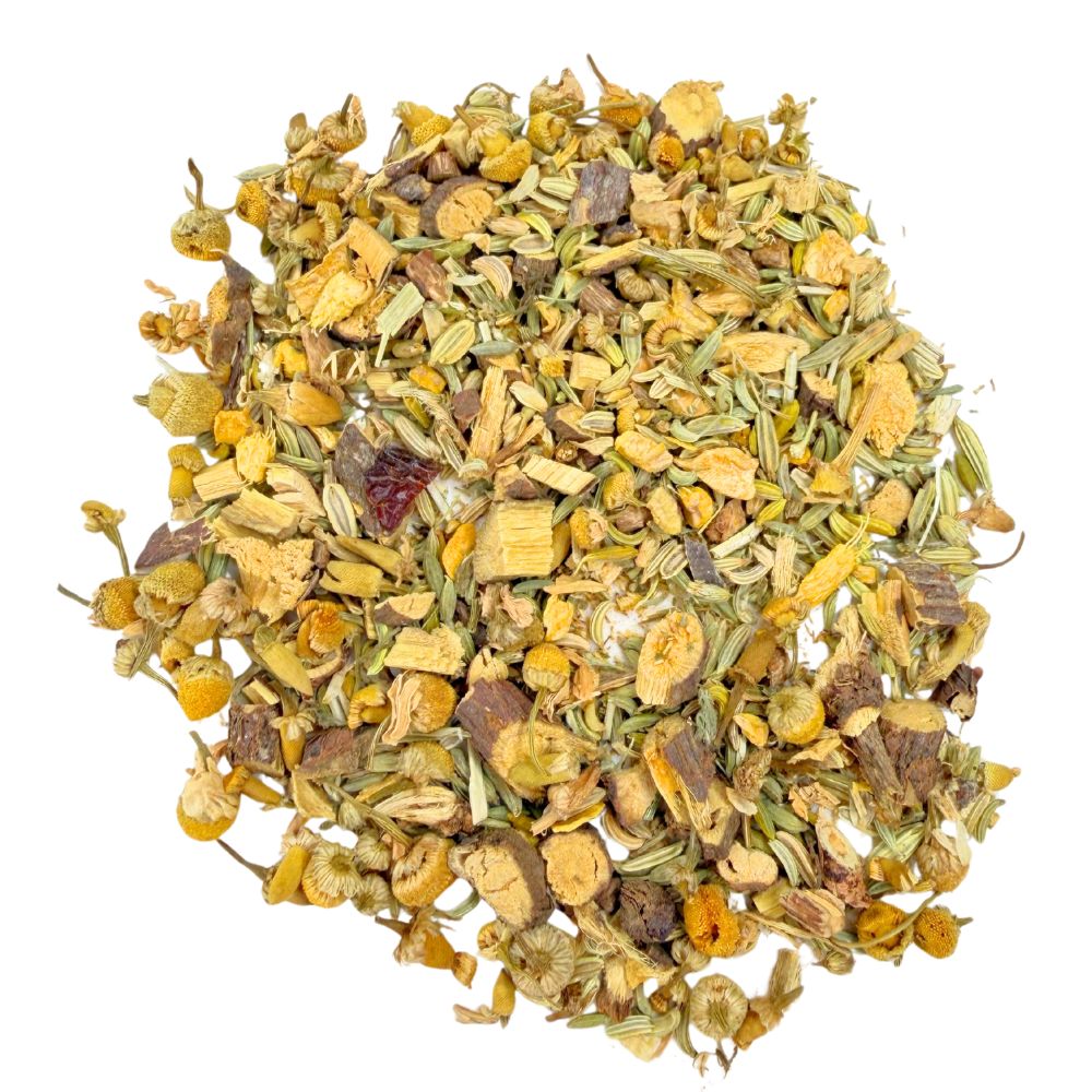 Nahaufnahme von getrockneten Kräutern und Blüten. Die Mischung enthält Kamillenblüten, Fenchelsamen und Wurzelstücke.