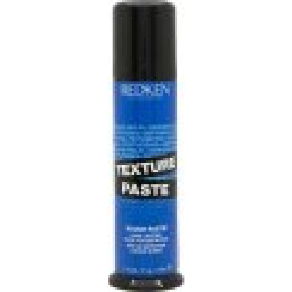 Zylinderförmige Tube. Schwarzer Deckel, blauer Körper mit weißer Schrift. "Redken" und "Texture Paste" sichtbar.