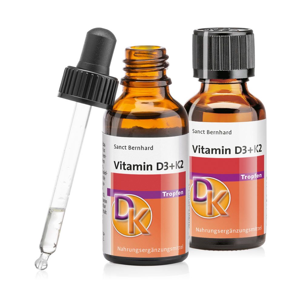 Zwei braune Flaschen mit Etiketten, eine mit Pipette. Aufschrift: Vitamin D3+K2 Tropfen. Marke: Sanct Bernhard.