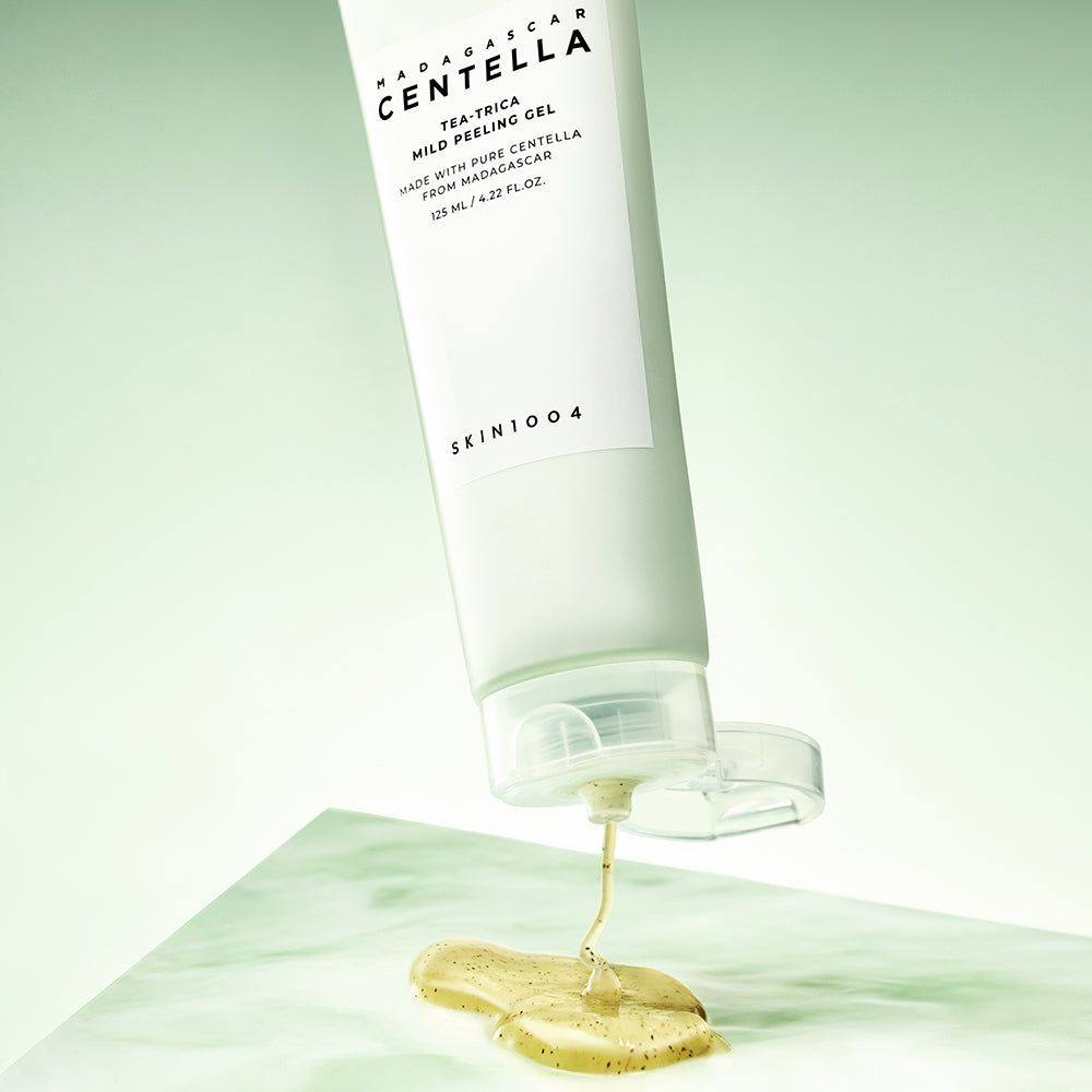Tube mit Gel, das herausfließt. Aufschrift: MADAGASCAR CENTELLA, Tea-Trica Mild Peeling Gel. Gel auf Oberfläche.