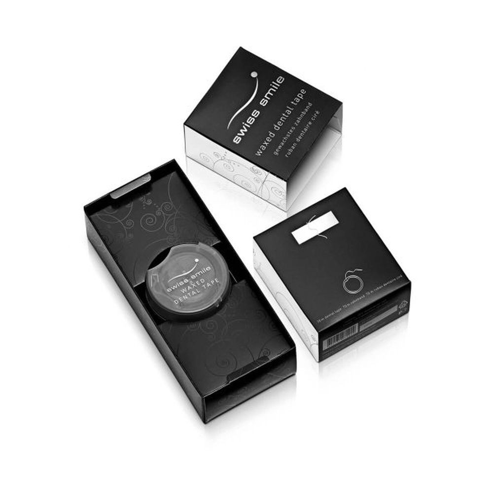 Zahnseide-Verpackung, schwarz mit silbernen Akzenten. Geöffnete Schachtel mit Zahnseide-Spule. Produktname und Marke sichtbar.