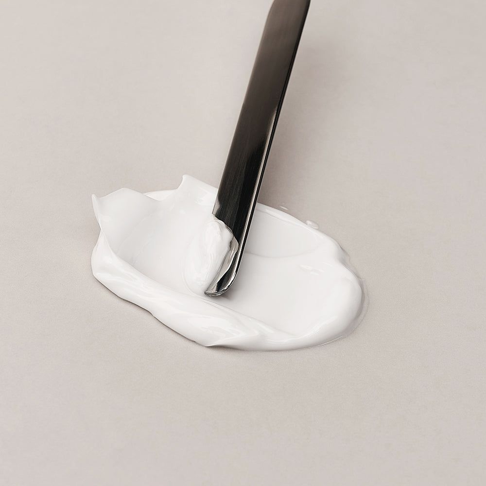 Eine Probe der DR.REJU-ALL Advanced LC-Ceramide Barrier Cream, die mit einem Spatel entnommen wird.