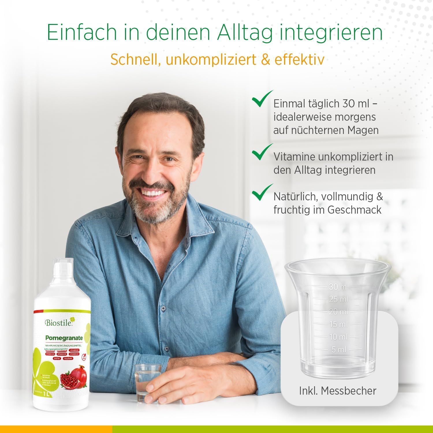 Mann trinkt Glas Wasser neben Biostile Granatapfelsaft Flasche und Messbecher.