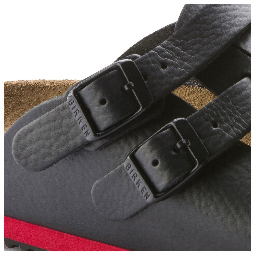 Detailansicht der Schnallen einer schwarzen Pantolette. Birkenstock-Logo auf den Schnallen.