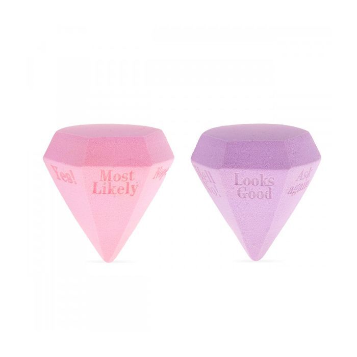 Zwei diamantförmige Make-up-Schwämme. Einer rosa, einer lila. Aufschrift: "Most Likely" und "Looks Good".