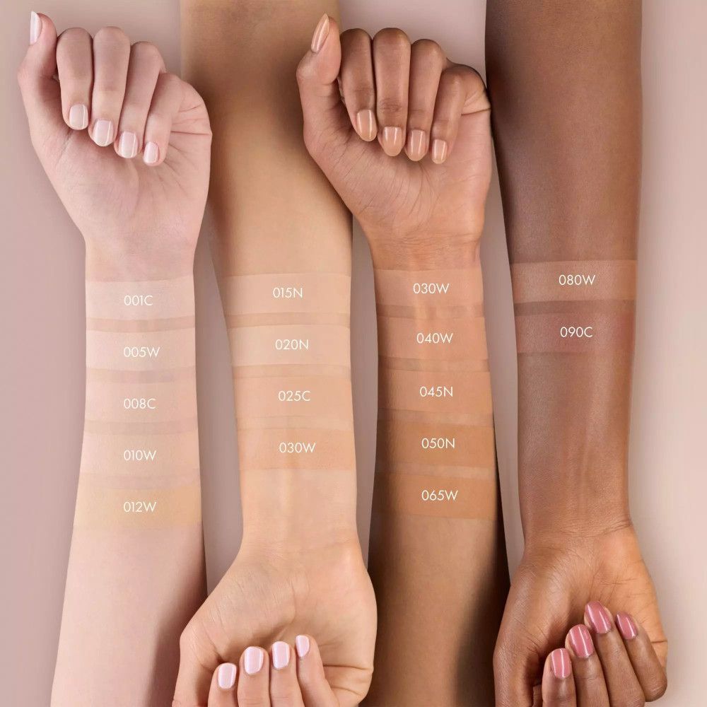 Arme mit verschiedenen Hauttönen. Aufgetragenes Foundation-Swatch. Beschriftung mit Farbnummern.