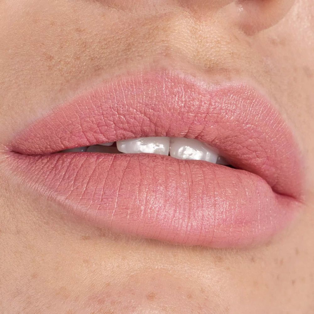 Nahaufnahme von Lippen, die mit einem rosafarbenen Lippenstift geschminkt sind. Die Lippen sind leicht geöffnet.