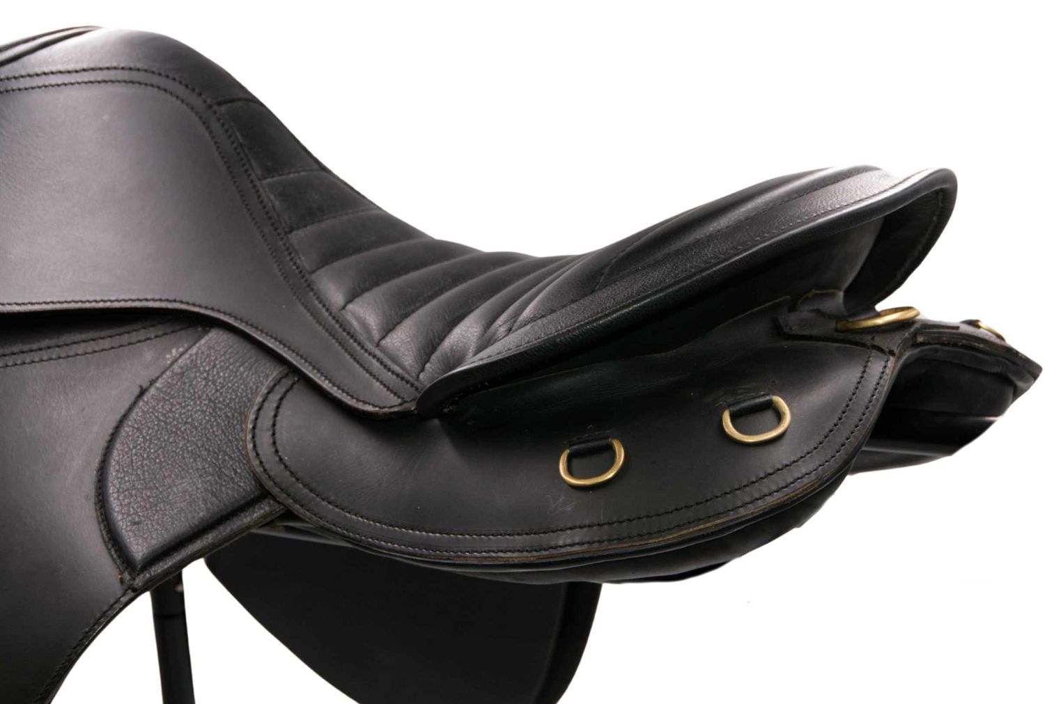 Schwarzer Sattel, Detailansicht. Gepolsterte Sitzfläche, Steppnähte, Messingringe.