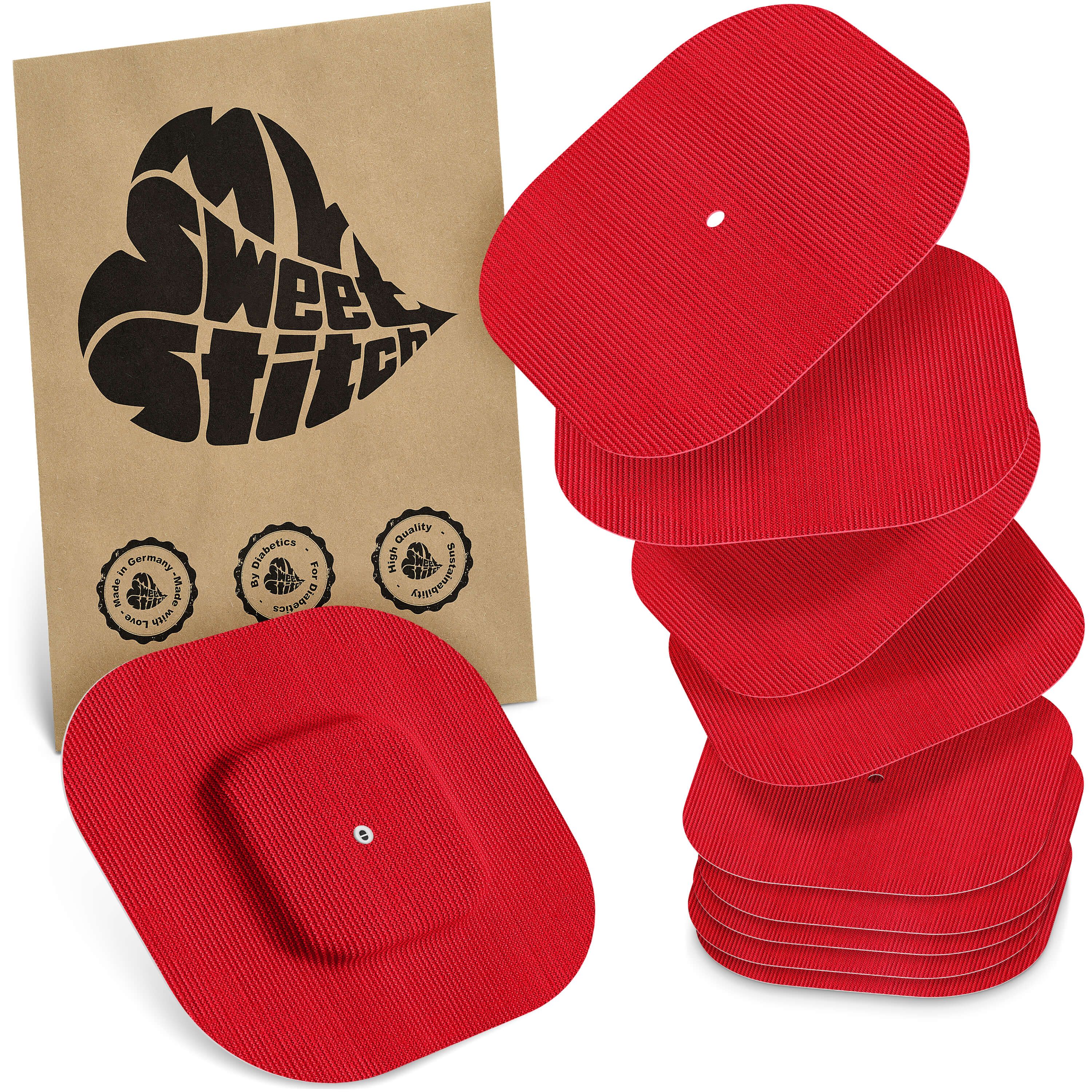 Rote, rechteckige Pads mit gerippter Oberfläche, gestapelt. Ein Pad mit quadratischem Aufsatz liegt vorne. Eine braune Papiertüte mit Herz-Logo und Qualitätssiegeln ist links.