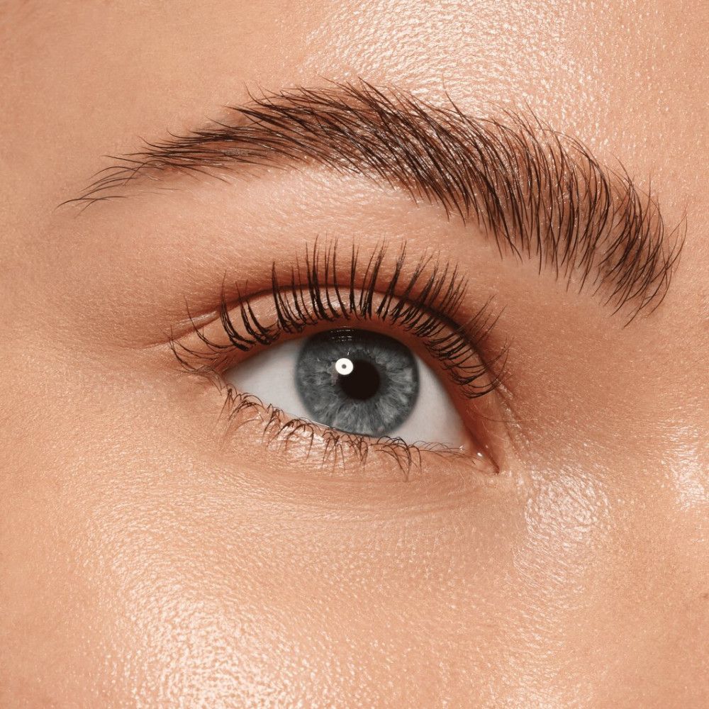 Nahaufnahme eines Auges mit getuschten Wimpern. Das Auge ist blau.