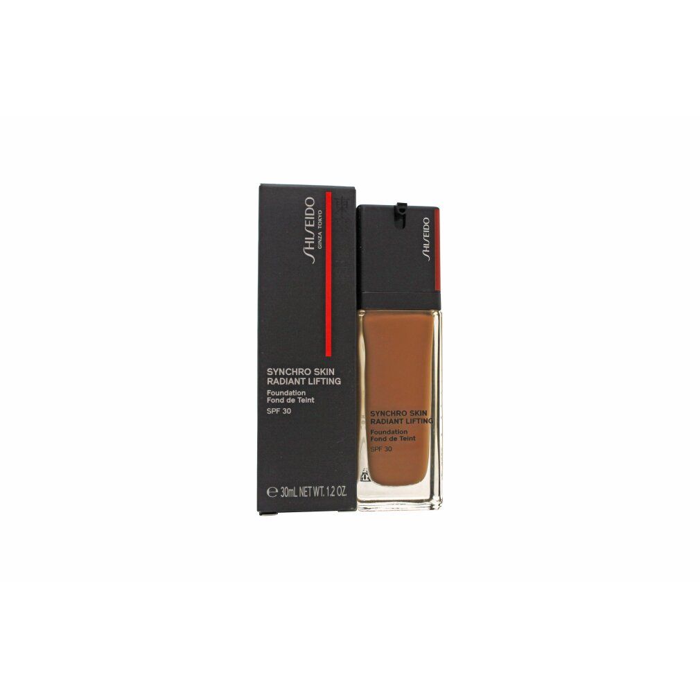 Shiseido Synchro Skin Foundation mit Verpackung. Schwarze Schachtel und Flasche. Produkttext und SPF 30 sichtbar.
