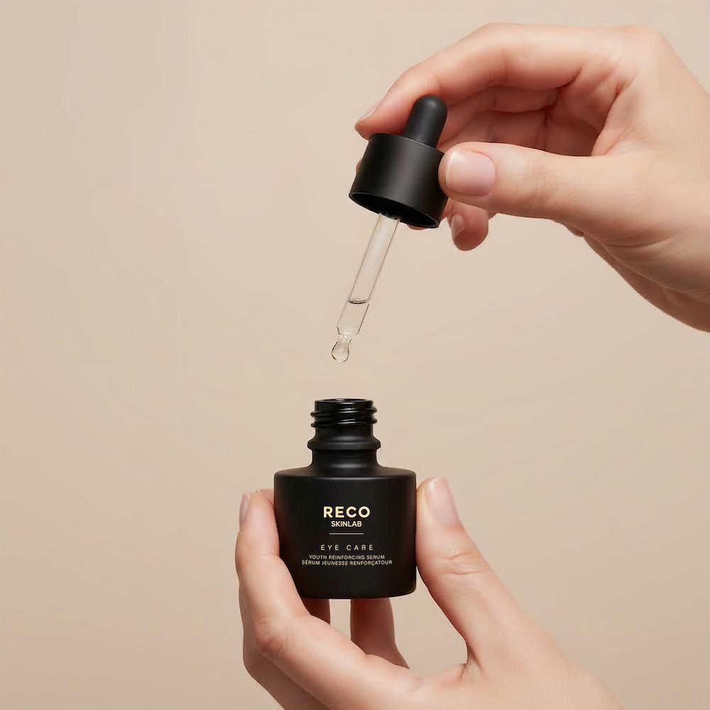 Hände halten eine schwarze Flasche von RECO SKINLAB. Dosierpipette wird in die Flasche eingesetzt. Beschriftung: Eye Care Serum.