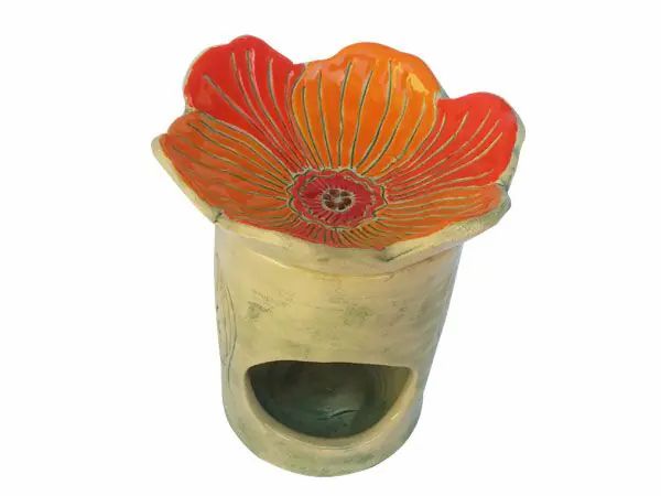 Duftlampe mit orangefarbener Blütenform. Zylindrischer Körper mit Blattmuster. Loch für Teelicht.