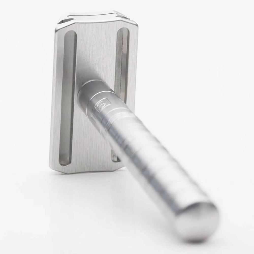 Sicherheitsrasierer AL13 Silber, Metall, von unten betrachtet. Griff mit Rillen und HS-Logo. Rasierkopf mit Klinge.