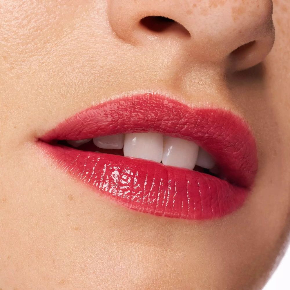 Nahaufnahme von Lippen mit rotem Lip Tint. Weiße Zähne sind sichtbar.