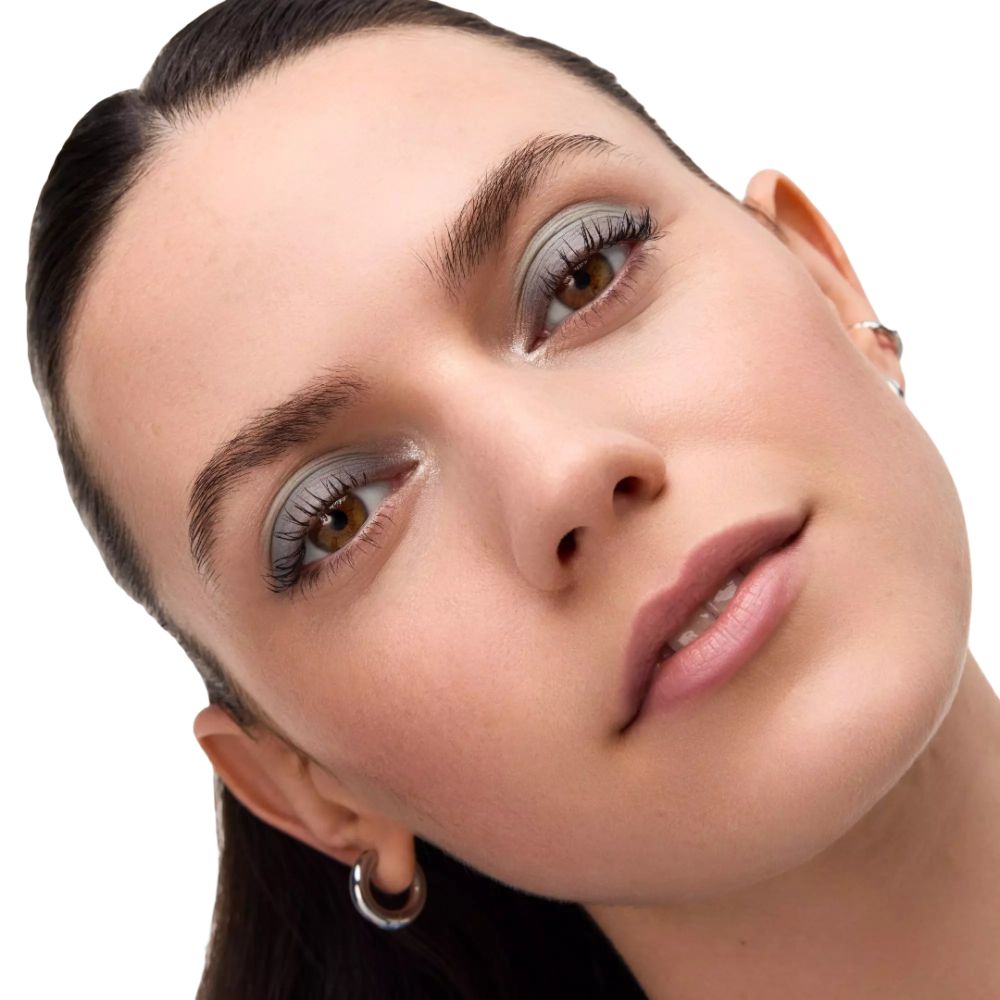 Nahaufnahme eines Gesichts mit geschminkten Augen. Helle Lidschattenfarben. Person mit braunen Augen und silbernen Ohrringen.