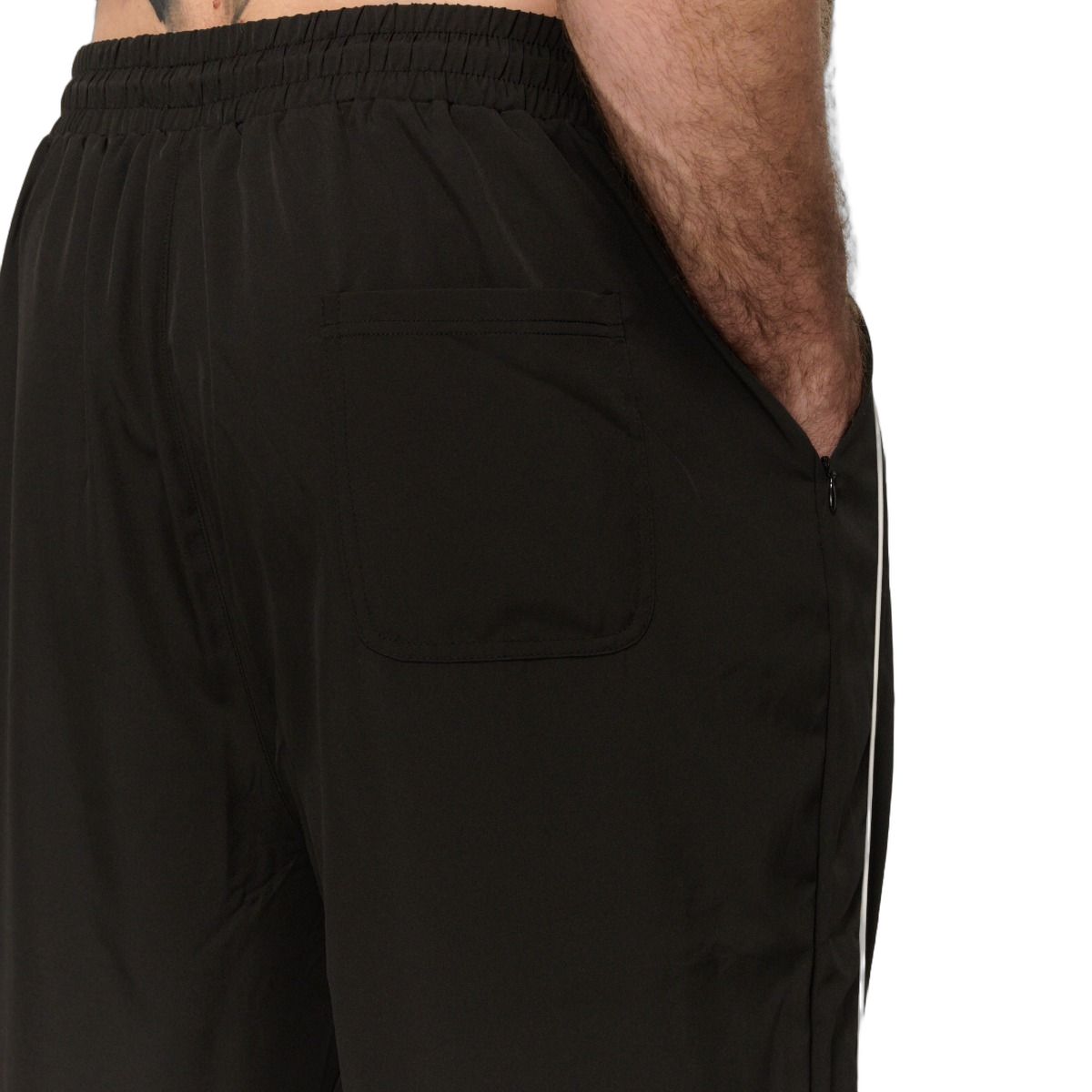Rückansicht einer schwarzen Herren-Jogginghose mit seitlichen weißen Streifen.