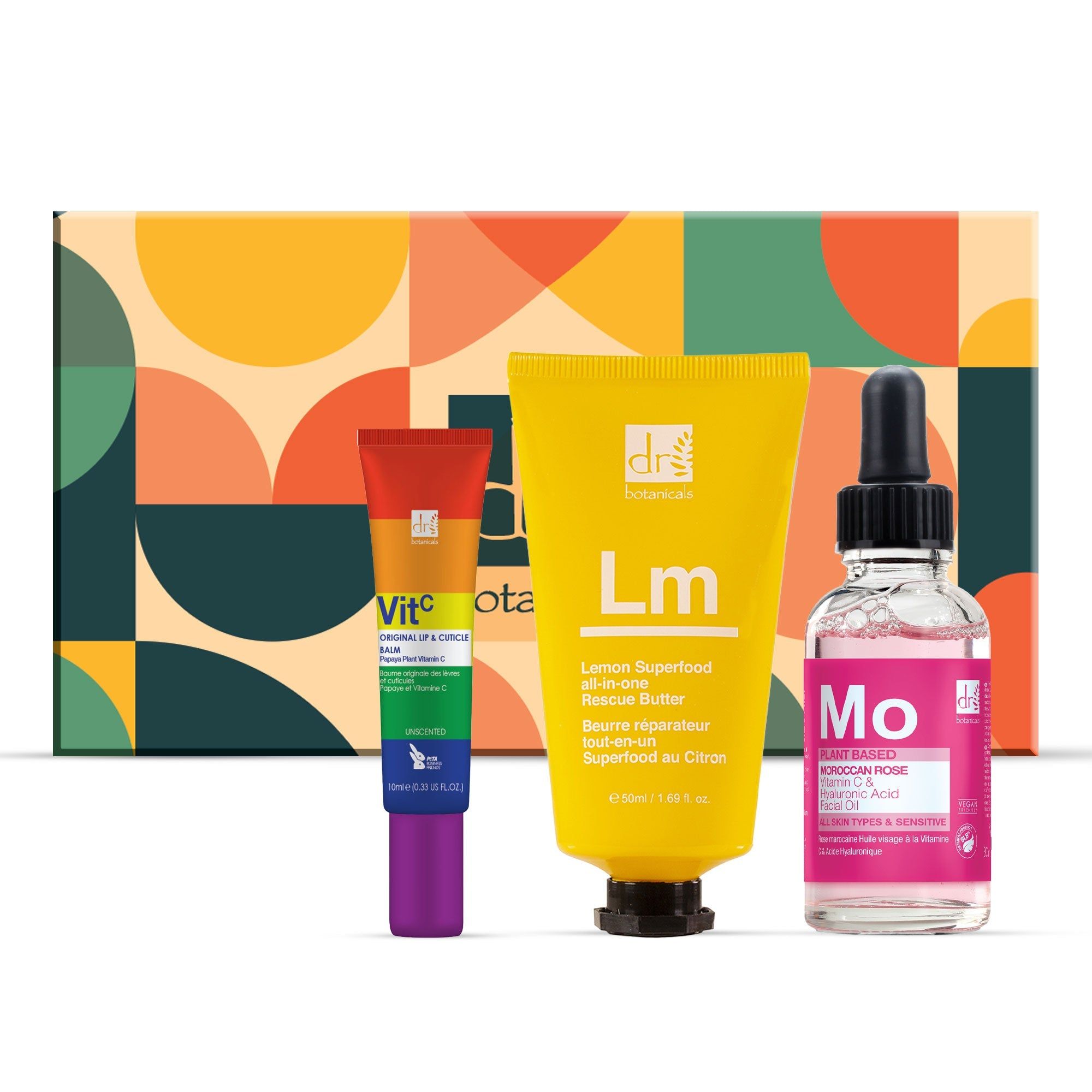 Geschenkset mit drei Produkten: Lippenbalsam, Creme und Serum. Verpackung mit farbenfrohem Muster. Produkte mit Schriftzügen.
