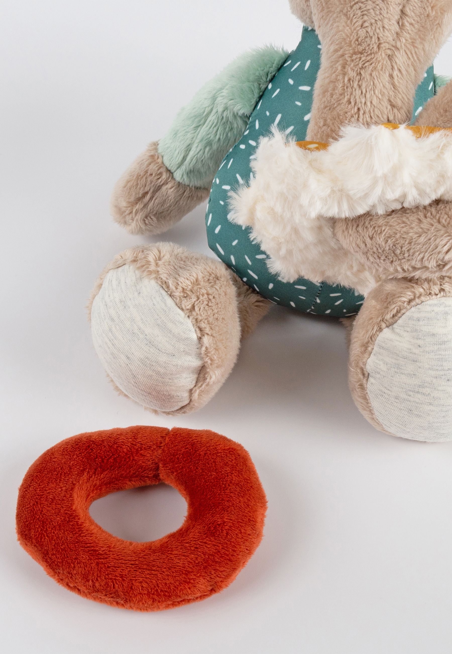 Stoffelefant mit orangefarbenem Ring und Bein. Der Ring liegt neben dem Elefanten.
