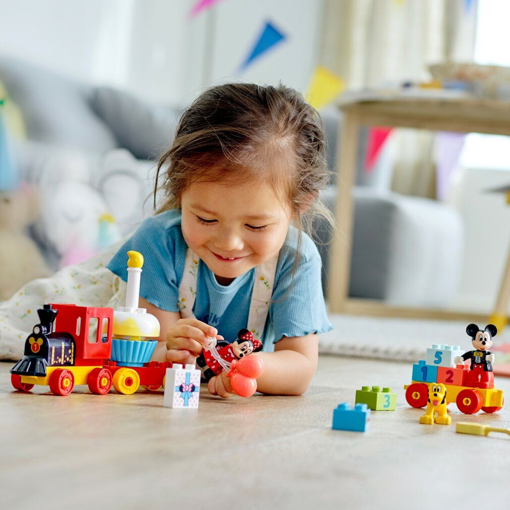 Kind spielt mit LEGO Duplo 10941 Mickys und Minnies Geb.zug. Zug, Mickey, Minnie, Pluto, Geschenk und Zahlenblöcke.