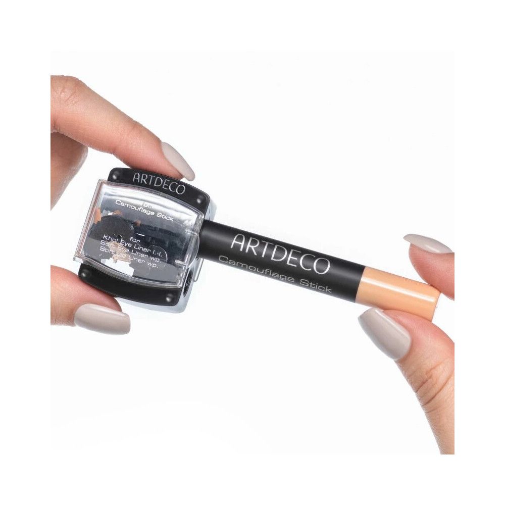 Artdeco Spitzer Duo. Schwarzer Spitzer mit transparentem Deckel. Ein Camouflage Stick wird gehalten.