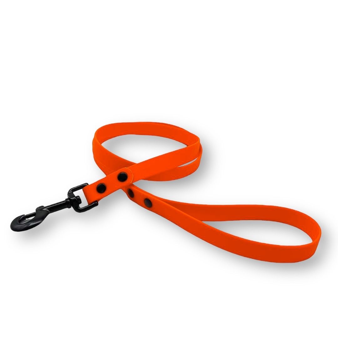 Neonorange Hundeleine mit schwarzem Karabinerhaken. Aus BioThane®-Material. Schwarze Nieten an der Handschlaufe.