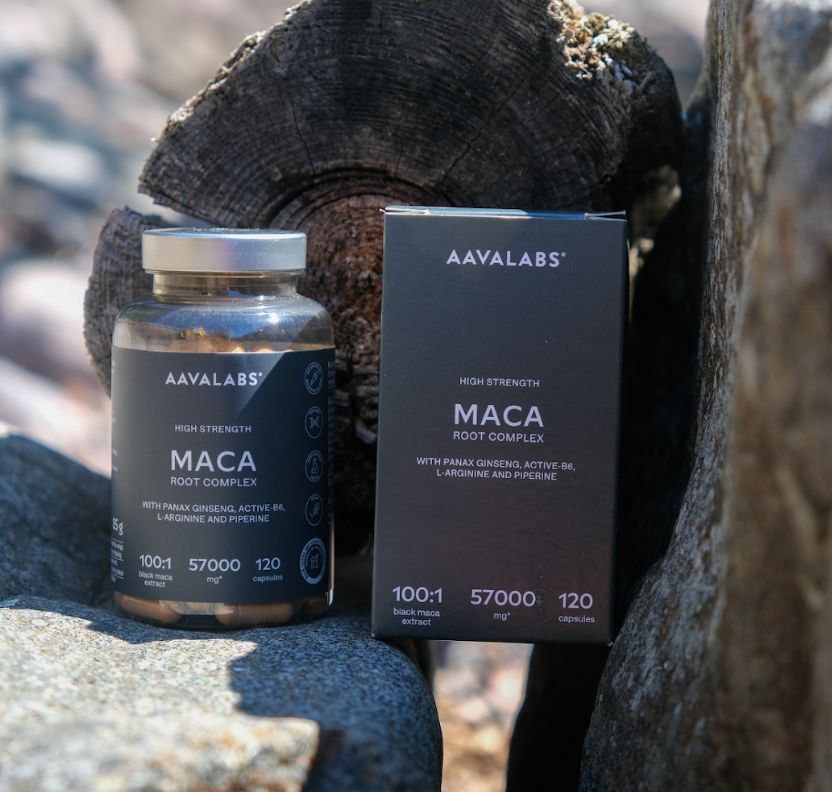 Flasche und Karton Aavalabs Maca Kapseln neben Holz und Steinen.