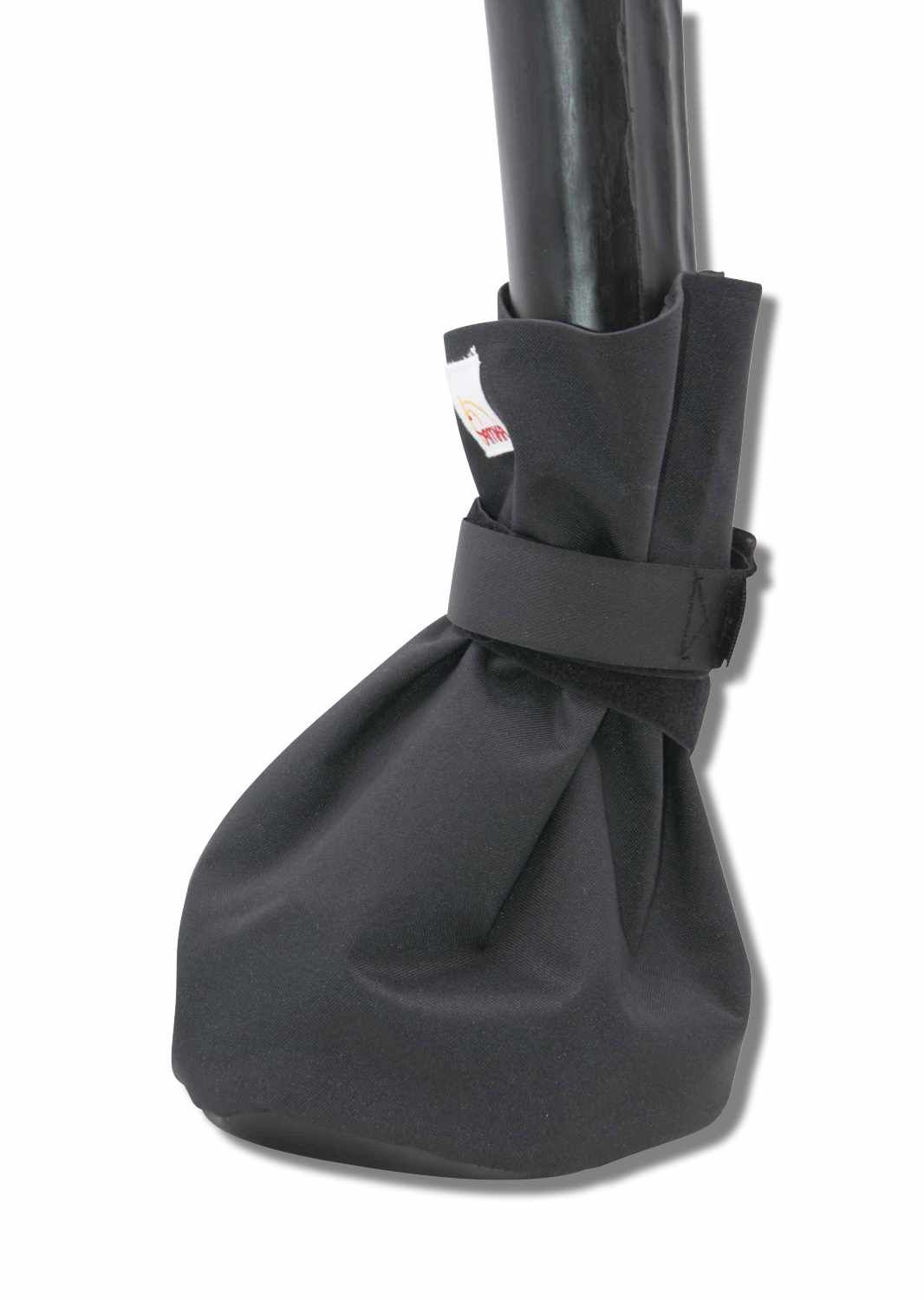 Schwarzer Hufverbandschutz, um einen Huf befestigt. Mit Klettverschluss. Kleines Etikett.
