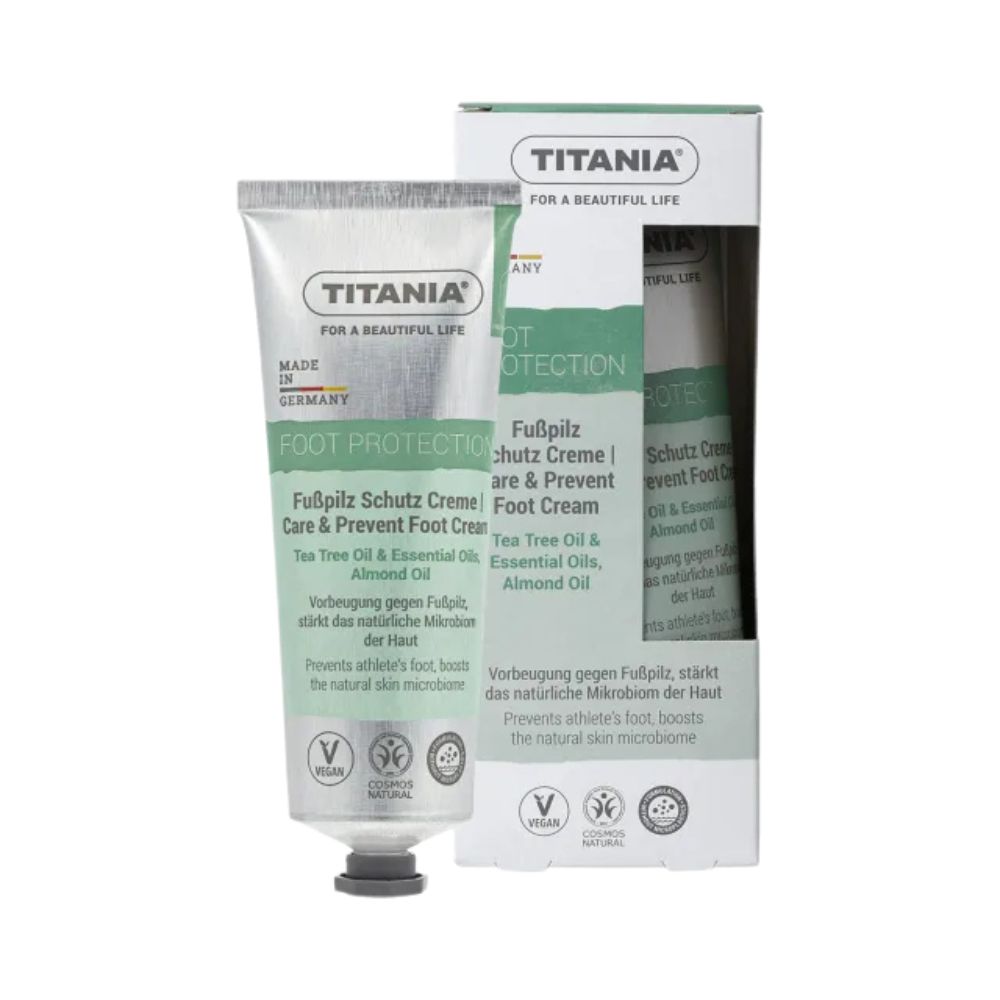 Creme-Tube und Verpackung. Aufschrift: TITANIA, Fußpilz Schutz Creme. Enthält Teebaumöl und Mandelöl. Vegan.