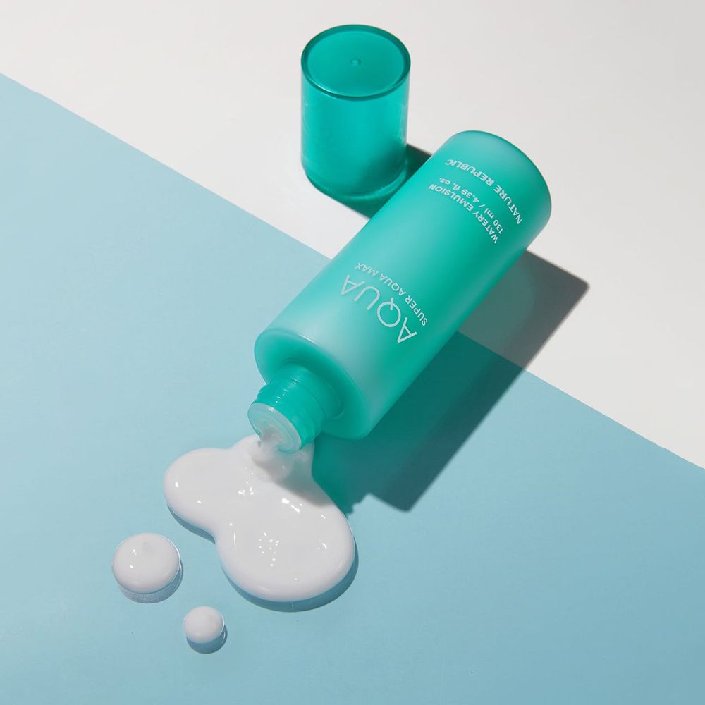 Türkisfarbene Flasche mit Produkt auf blauem Untergrund. Produktname: AQUA Super Aqua Max Watery Emulsion. Weiße Tropfen daneben.