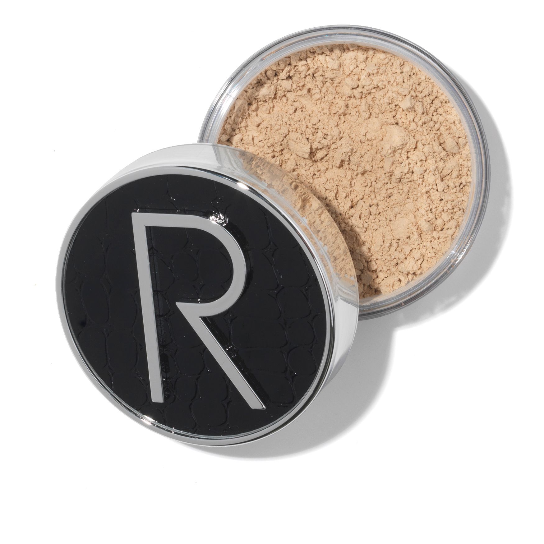 Behälter mit losem Puder. Schwarzer Deckel mit silbernem "R"-Logo. Offener Deckel zeigt hellbraunes Puder. Silberner Rand.