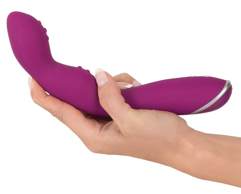 Hand hält einen lila Vibrator mit gebogener Form und Noppen. Silbernes Detail am Ende.