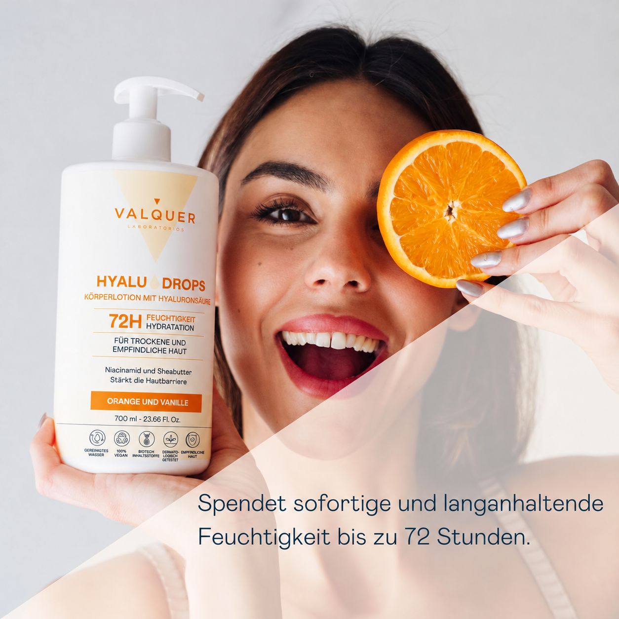 Frau hält eine Valquer Hyalu Drops Körperlotion-Flasche und eine Orangenscheibe.