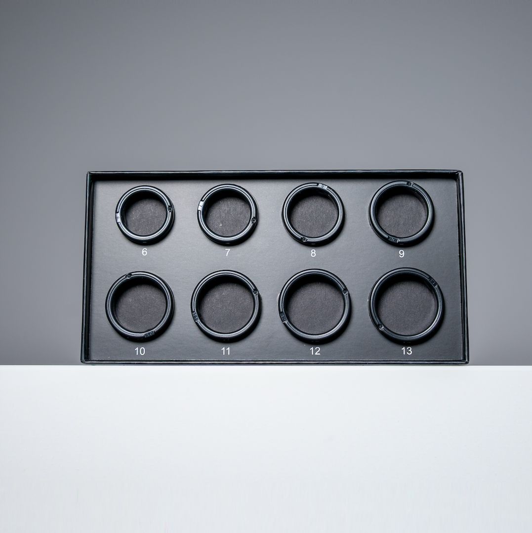 Schwarze Box mit acht kreisförmigen Aussparungen für Ringe. Größen: 6 bis 13.