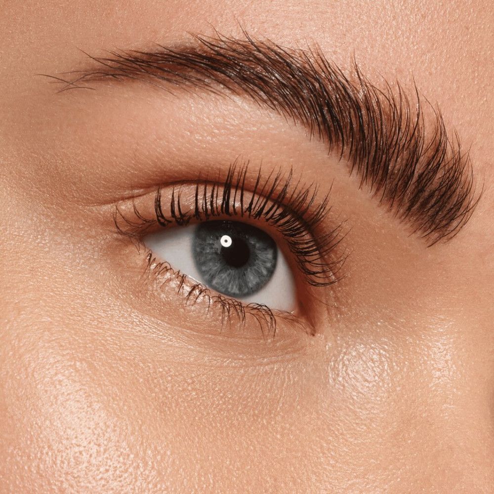 Nahaufnahme eines Auges mit geformter Augenbraue. Blaue Augenfarbe.