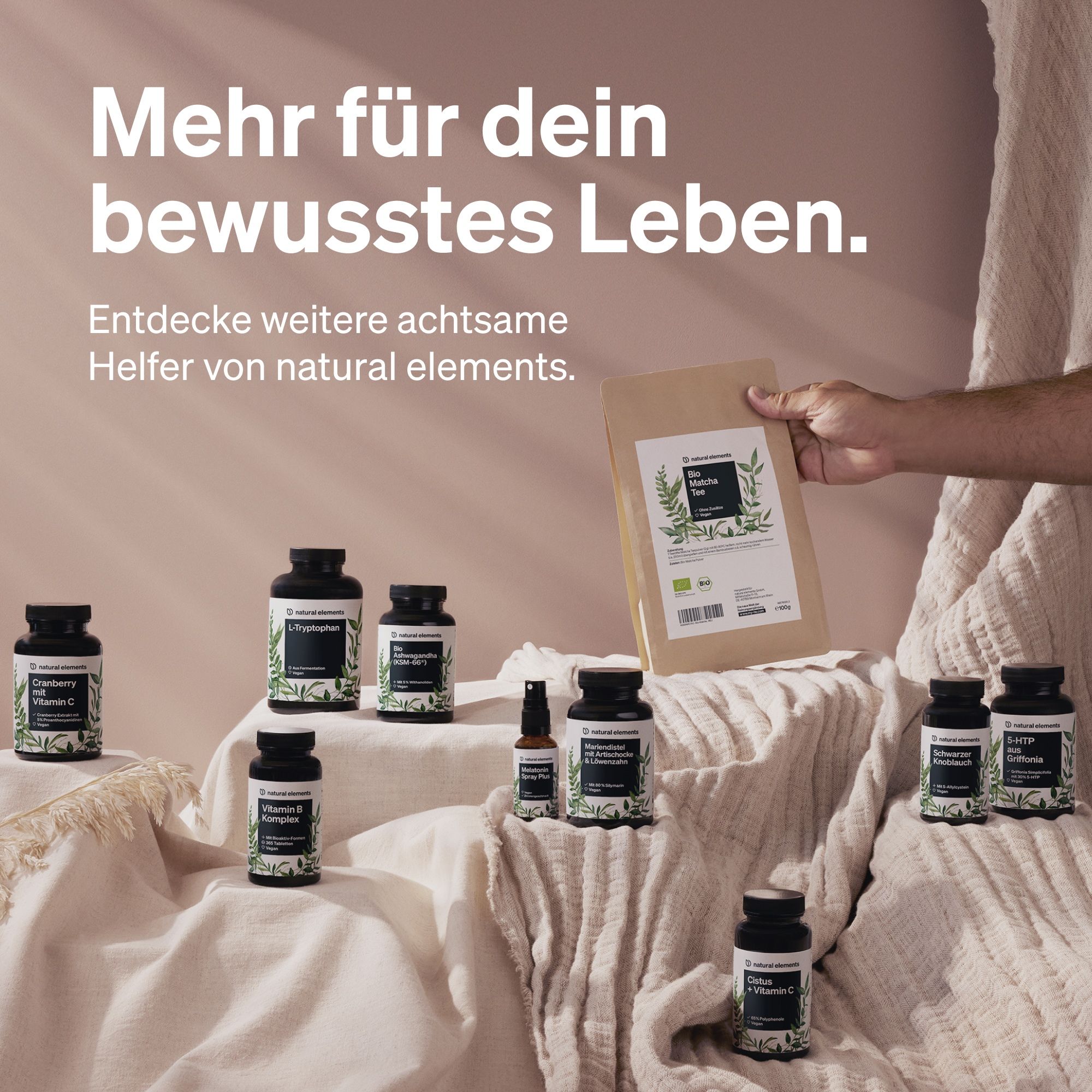 Verschiedene Flaschen und eine Tüte auf einer Stoffoberfläche. Text: Mehr für dein bewusstes Leben. Produkte von natural elements.