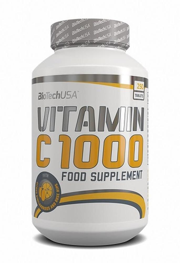Weiße Flasche mit gelbem Etikett. Aufschrift: Vitamin C 1000, 250 Tabletten. Marke: BioTechUSA. Mit Zitrusfrüchten und Hagebutten.
