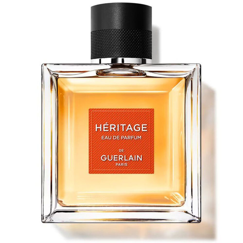 Héritage Eau de Parfum Flakon. Quadratischer Flakon mit schwarzem Verschluss. Orangefarbenes Etikett mit Schriftzug.