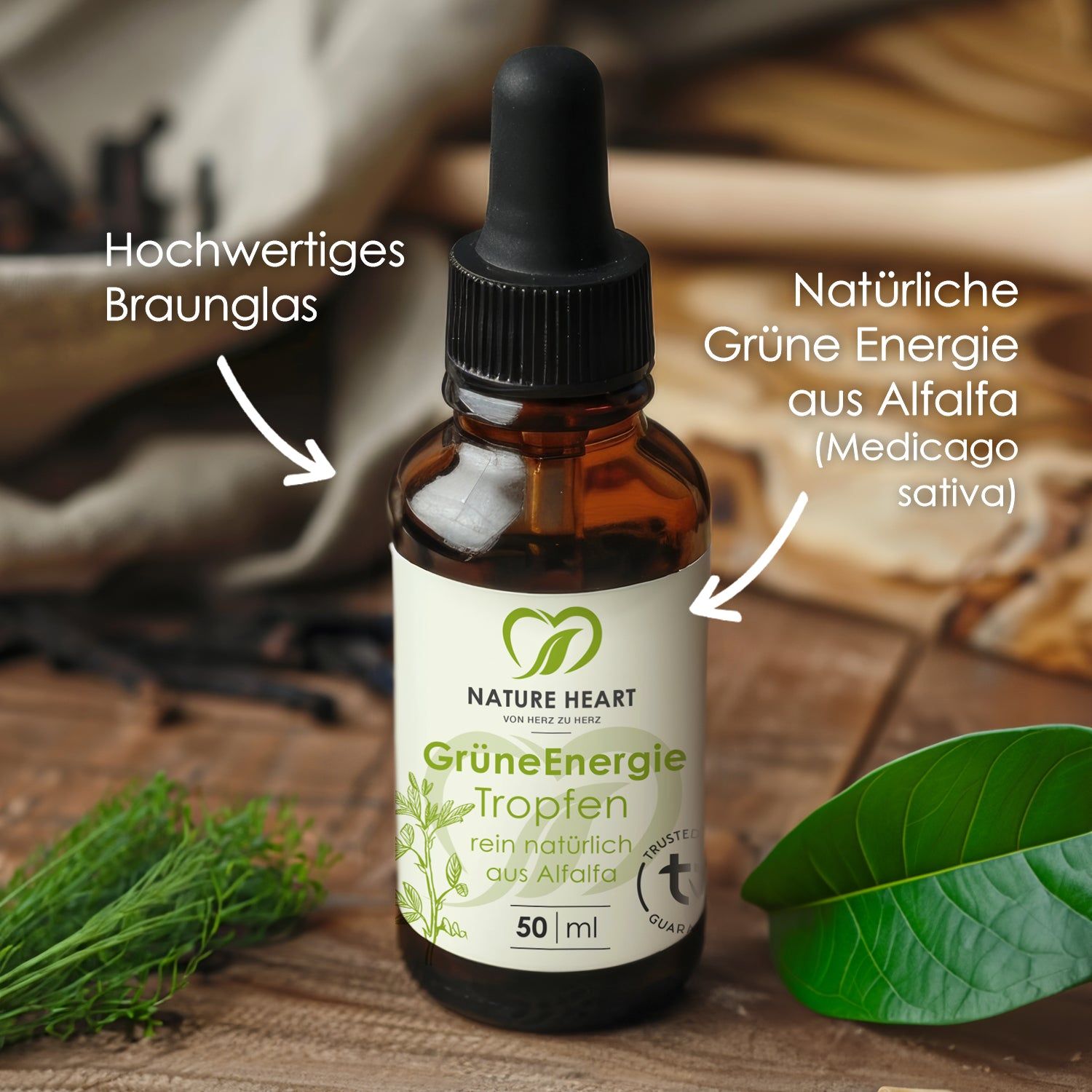Braunglasflasche mit Tropfer. Pfeile zeigen auf "Hochwertiges Braunglas" und "Natürliche Grüne Energie aus Alfalfa". Etikett mit Logo und Text.