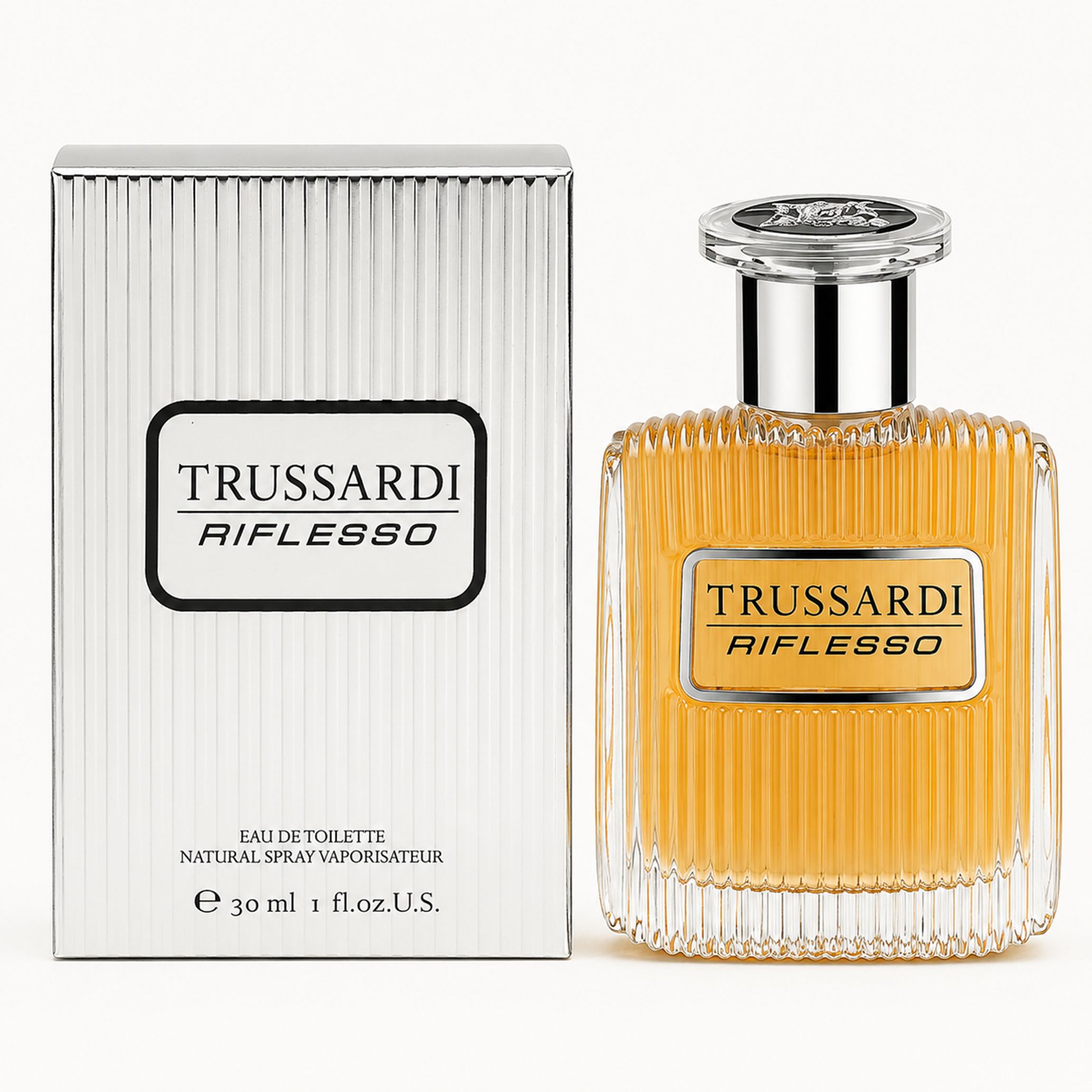 Trussardi Riflesso Eau de Toilette Spray. Flakon und Verpackung. Silberne Verpackung mit Logo. Klarer Flakon mit goldfarbener Flüssigkeit.