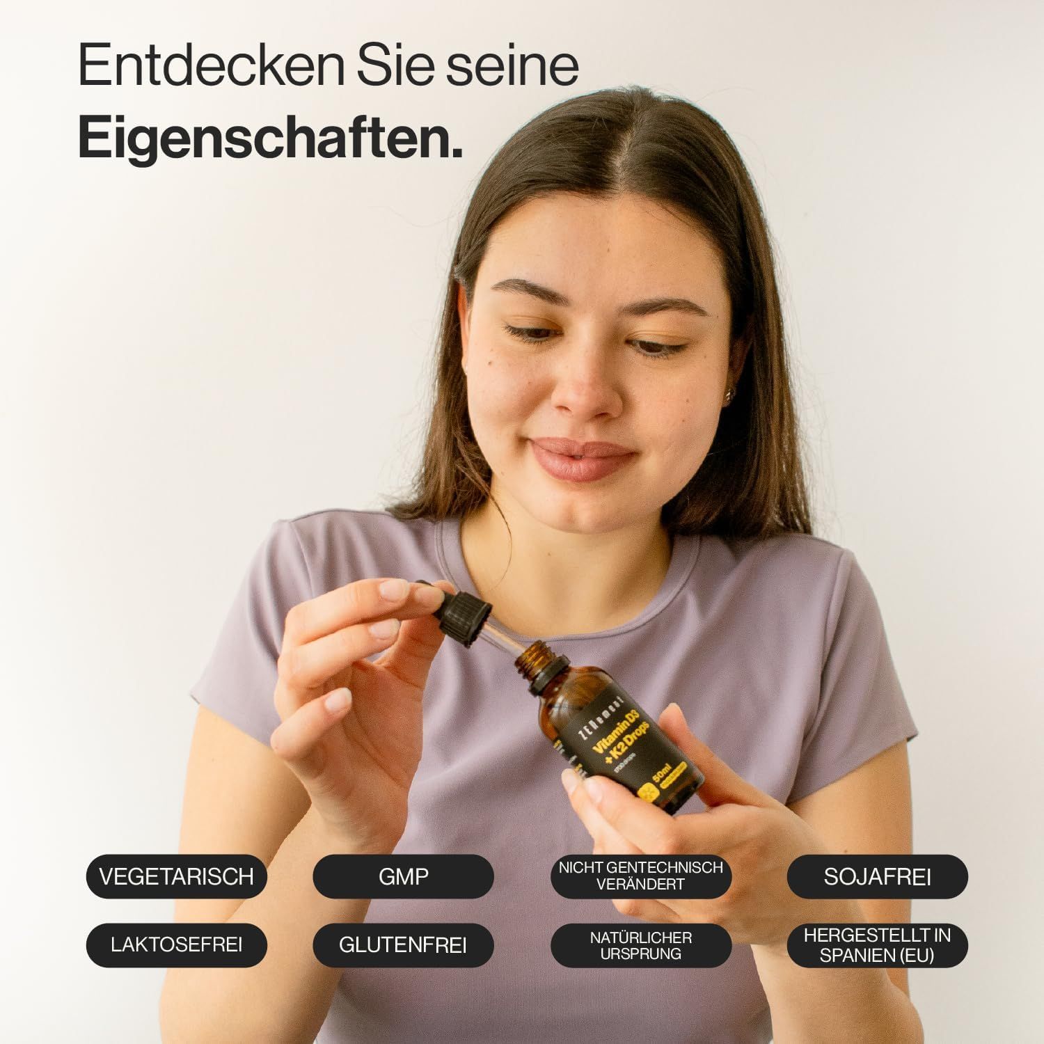 Frau hält eine Flasche mit Tropfer. Auf der Flasche steht: Vitamin D3 + K2 Tropfen. Auf dem Tisch sind verschiedene Siegel zu sehen.