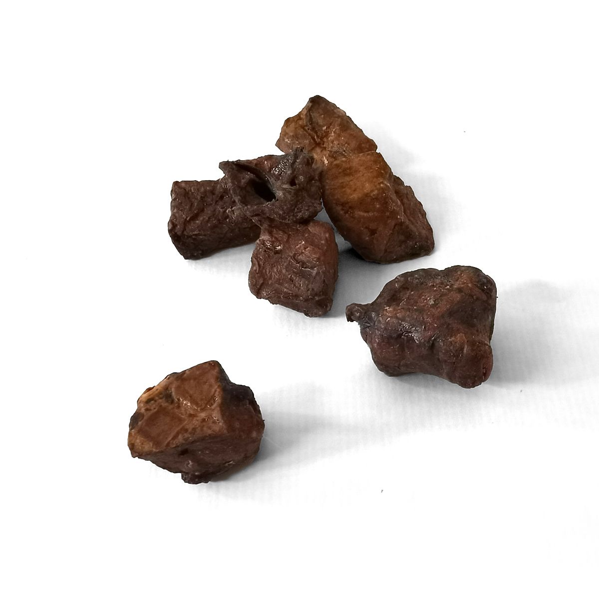Mehrere braune, unregelmäßig geformte Stücke auf weißem Hintergrund. Die Stücke scheinen getrocknet zu sein.