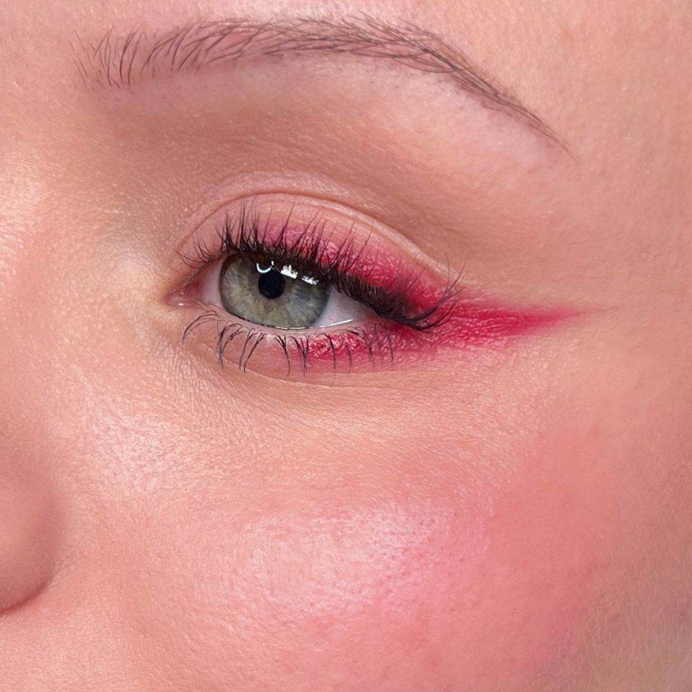 Nahaufnahme eines Auges mit rotem Eyeliner und Wimperntusche. Hautton.