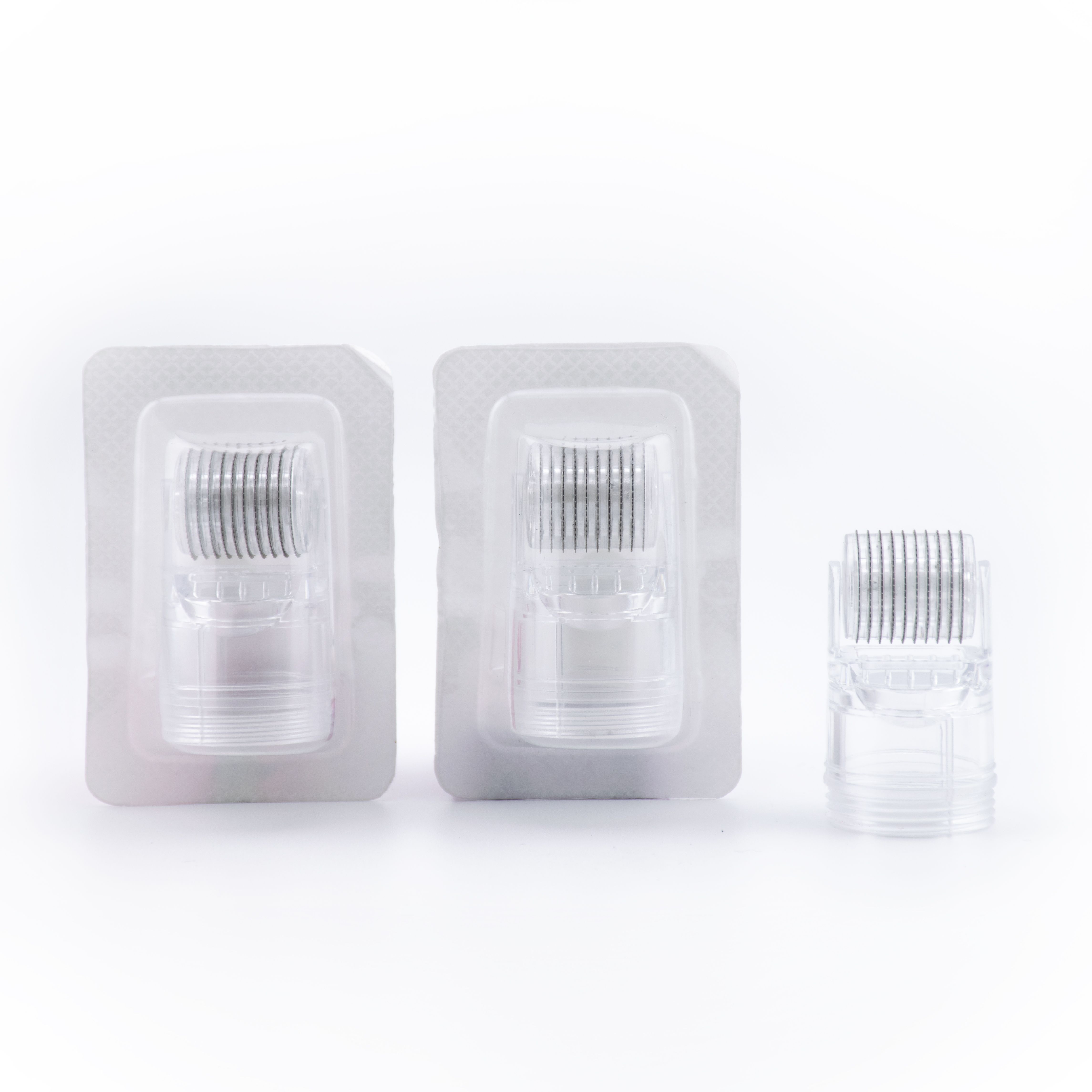 Drei Ersatzroller. Zwei in Blisterverpackung, einer lose. Rollen mit Mikronadeln, transparentes Gehäuse.