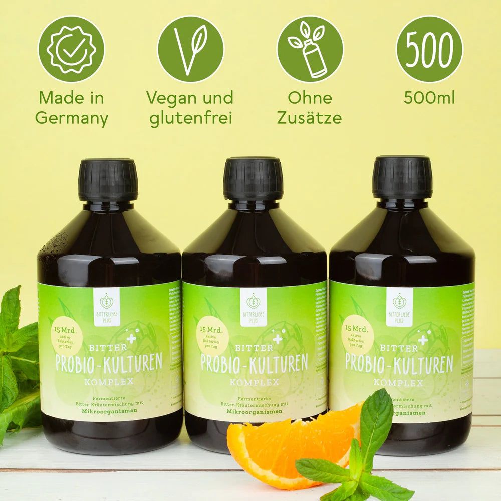 Drei Flaschen BitterLiebe Probio Kulturen Komplex, daneben eine Orange und Minze. Siegel: Made in Germany.