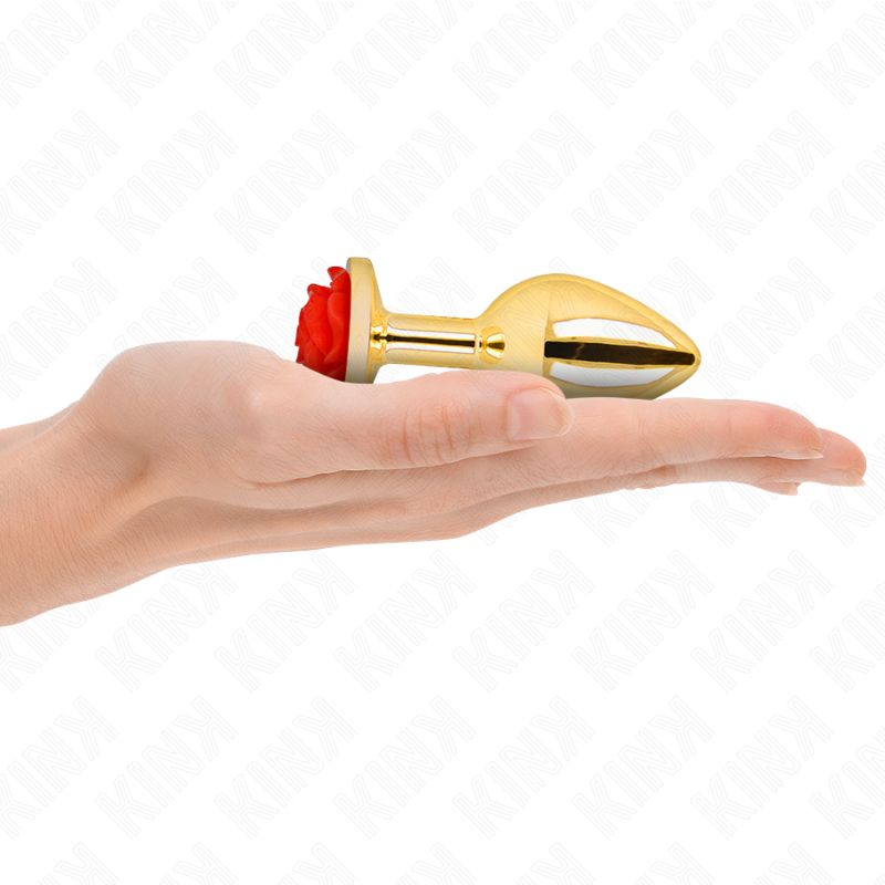 Goldfarbener Analplug mit roter Rose in einer Hand.